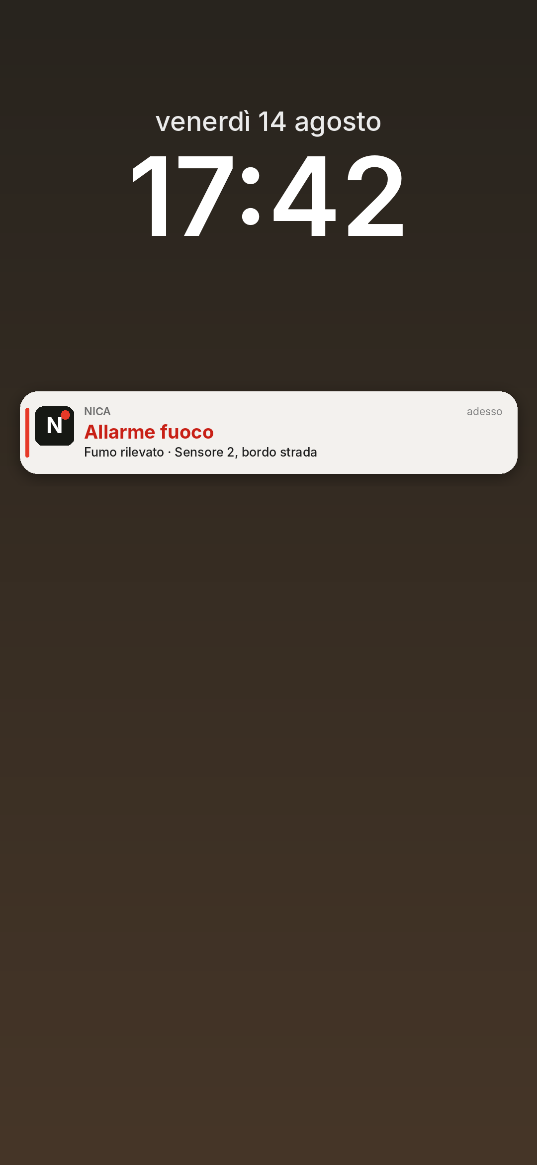 Schermata di blocco di un telefono con la notifica NICA: Allarme fuoco. Fumo rilevato, sensore 2, bordo strada.